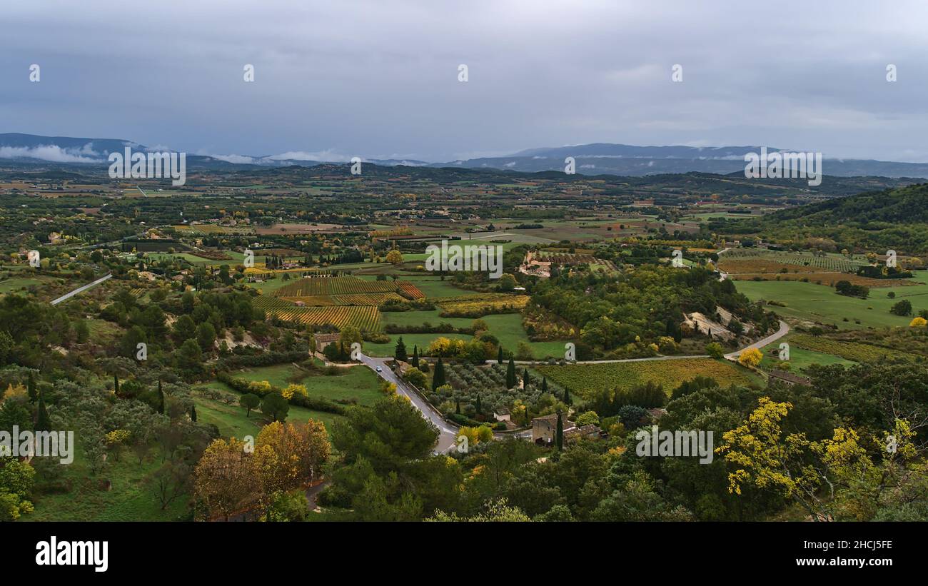Bella vista panoramica della valle del Luberon vicino al villaggio Gordes, Frence nella regione della Provenza in autunno con alberi colorati e vigneti in giornata nuvolosa. Foto Stock