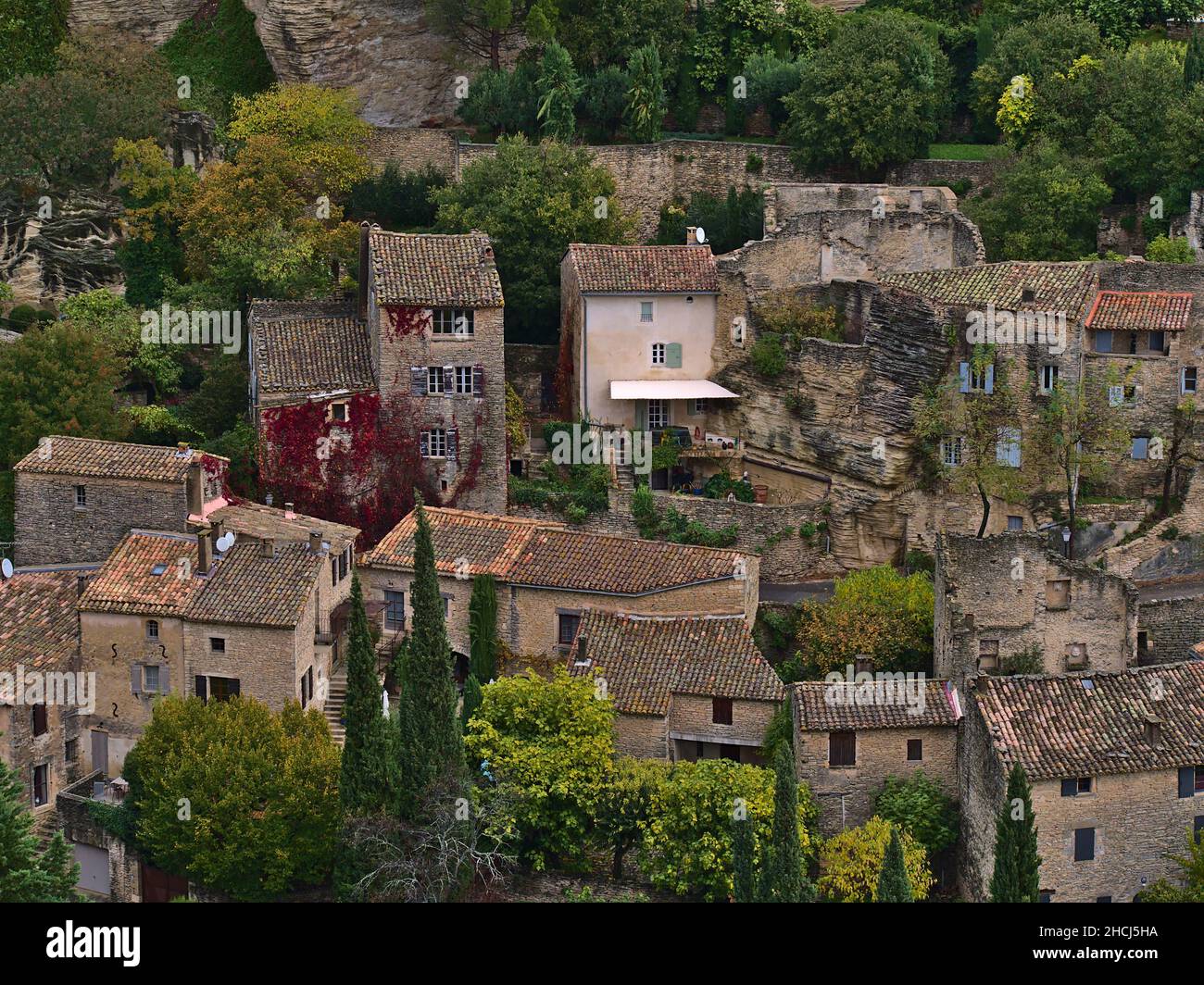 Vista ravvicinata di case storiche costruite in pietra tra rocce su una collina nel piccolo villaggio di montagna Gordes, Francia nella valle del Luberon nella regione della Provenza. Foto Stock