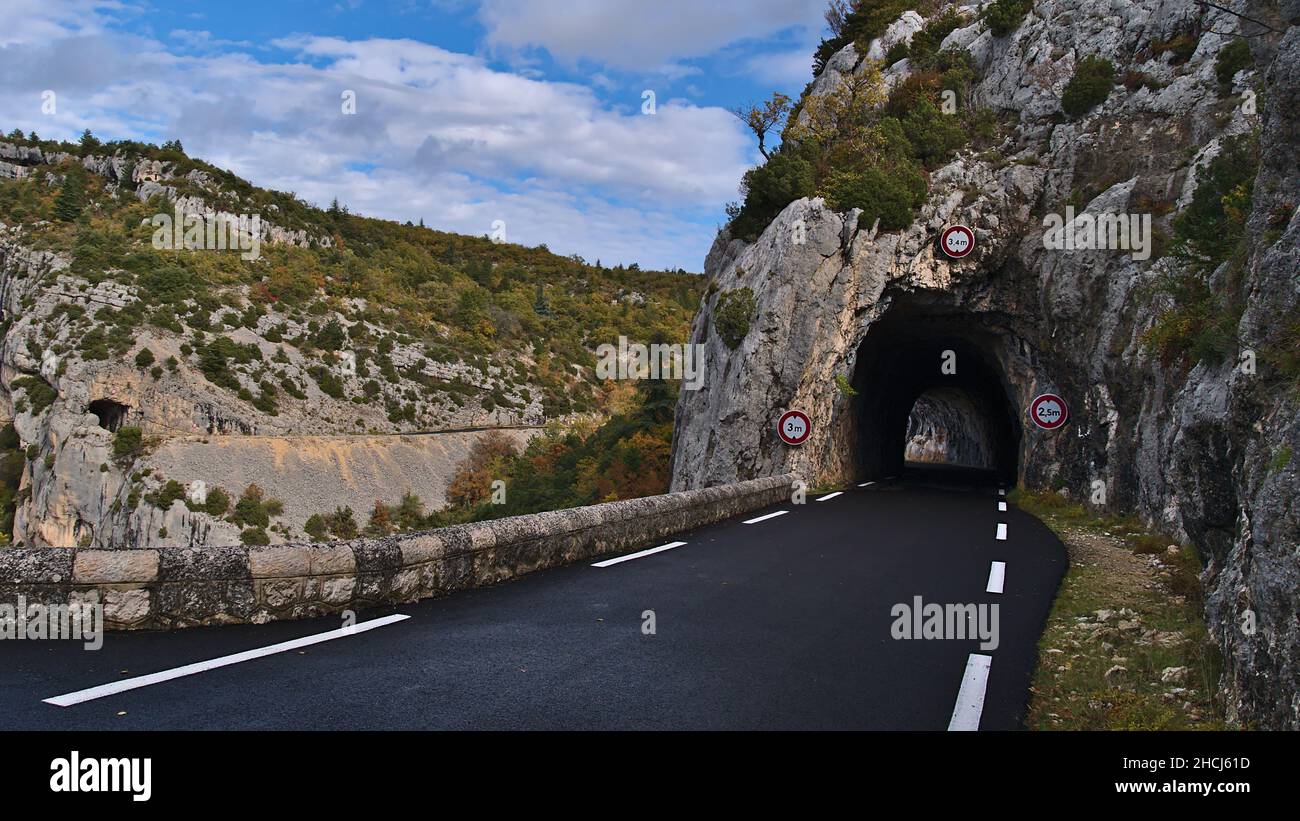 La prospettiva di una strada di campagna D942 sopra il canyon Gorges de la Nesque nei Monti Vaucluse nella regione della Provenza, Francia con tunnel scuro. Foto Stock
