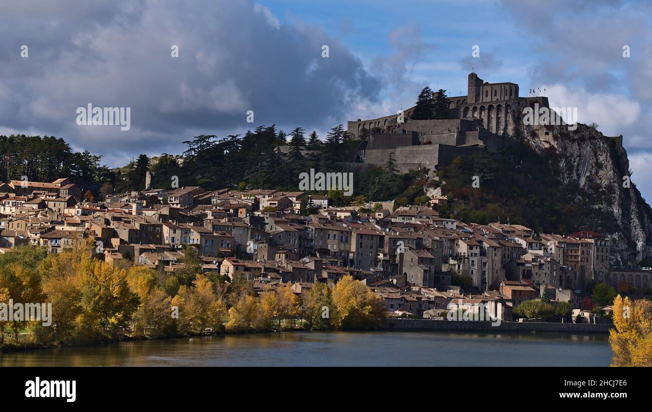 Bellissimo paesaggio urbano di piccola città Sisteron in Provenza, Francia con famosa cittadella situato su una roccia, edifici storici e Durance fiume di fronte. Foto Stock