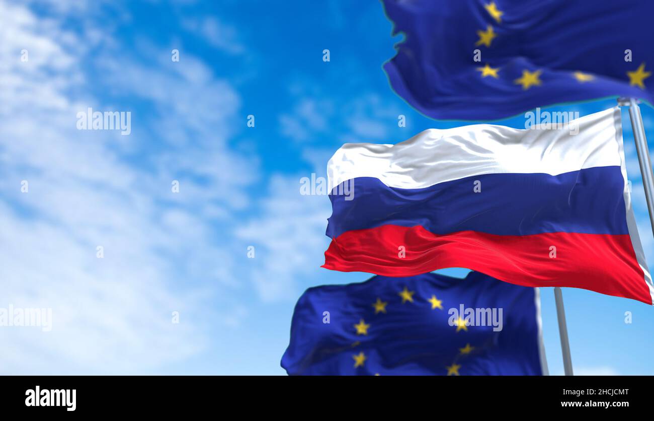 La bandiera nazionale della Russia che sventola tra due bandiere dell'Unione europea con il cielo blu sullo sfondo. Relazioni internazionali e diplomazia europea. Foto Stock