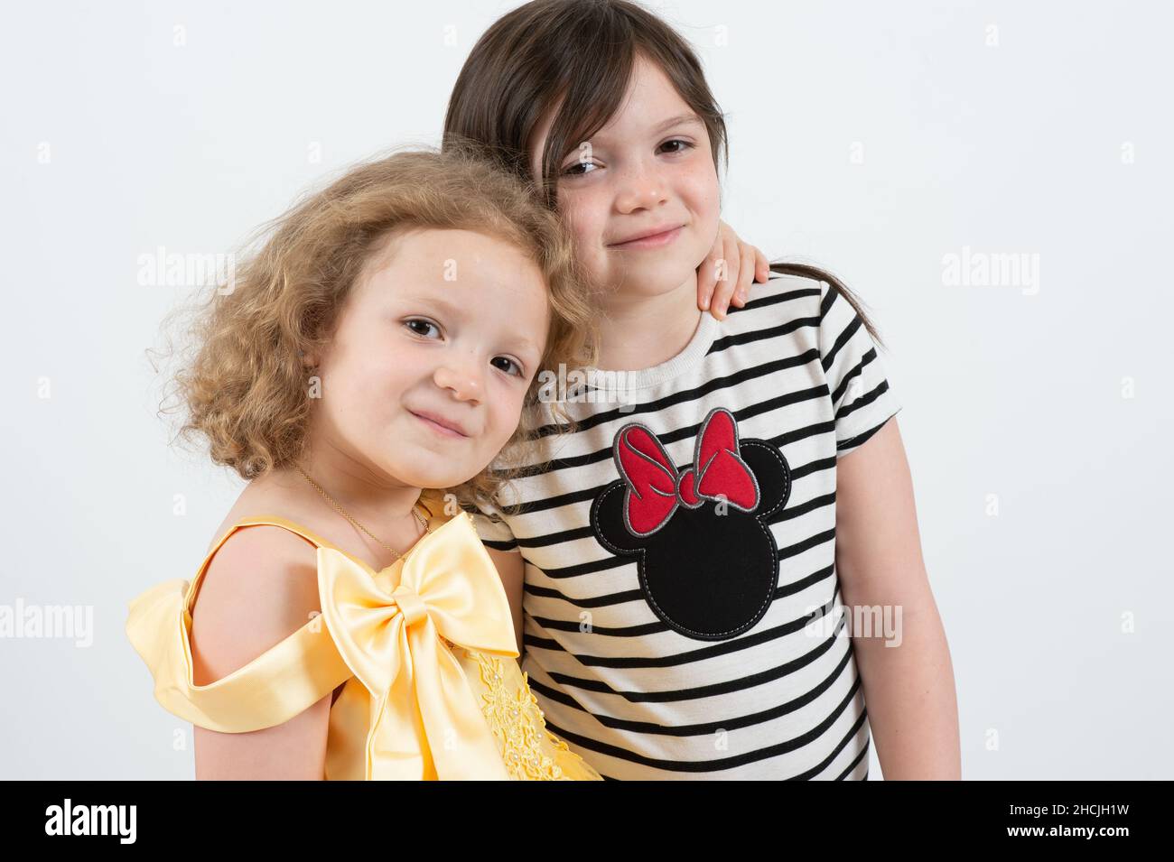 ritratto della ragazza di 5 anni con la sorella di 8 anni, sfondo bianco Foto Stock