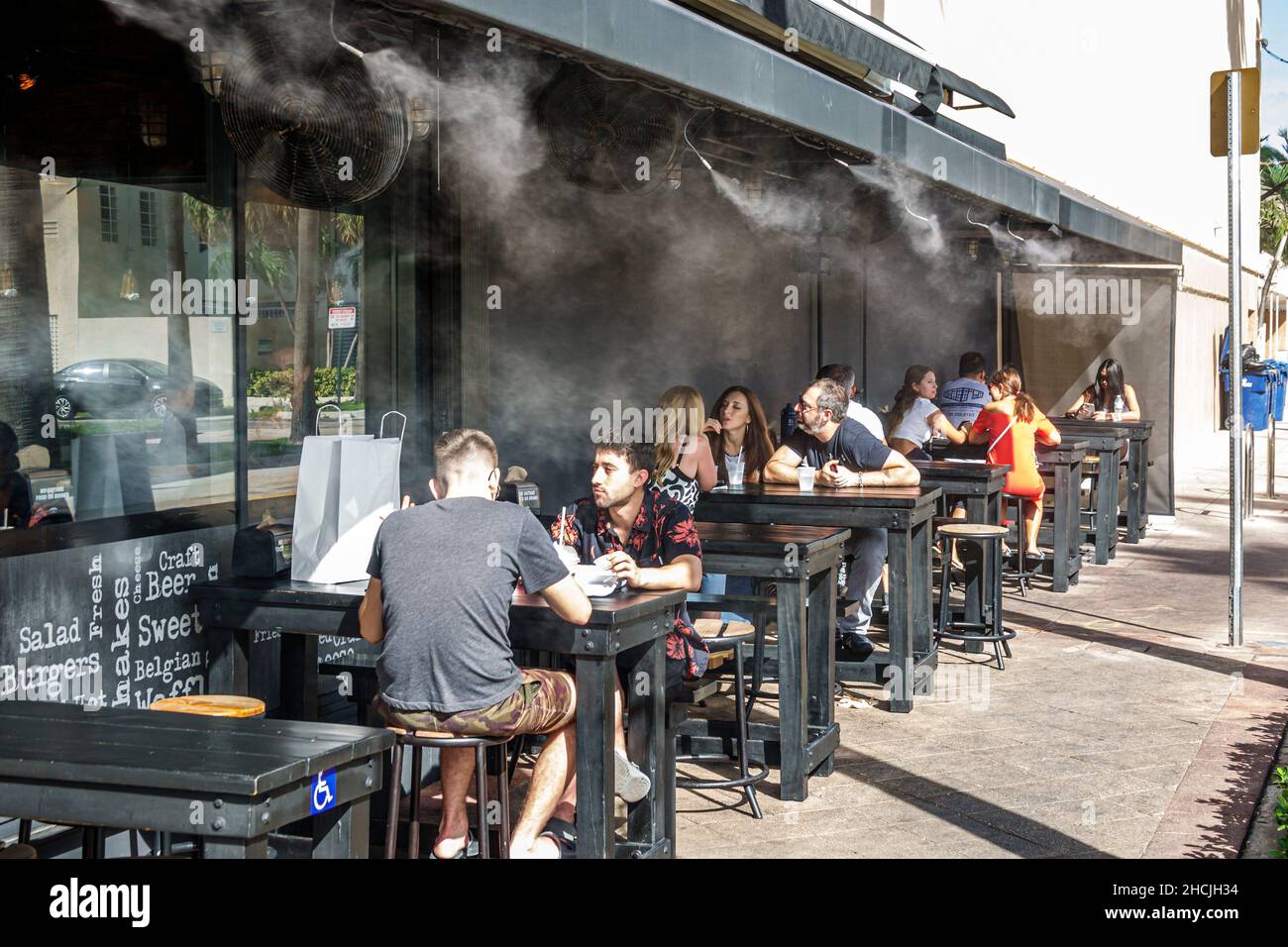 Miami Beach Florida North Beach Ristorante Burgers & Shakes all'esterno, all'aperto, cena a nebbie, sistema di raffreddamento, nebulizzazione d'acqua per i clienti Foto Stock