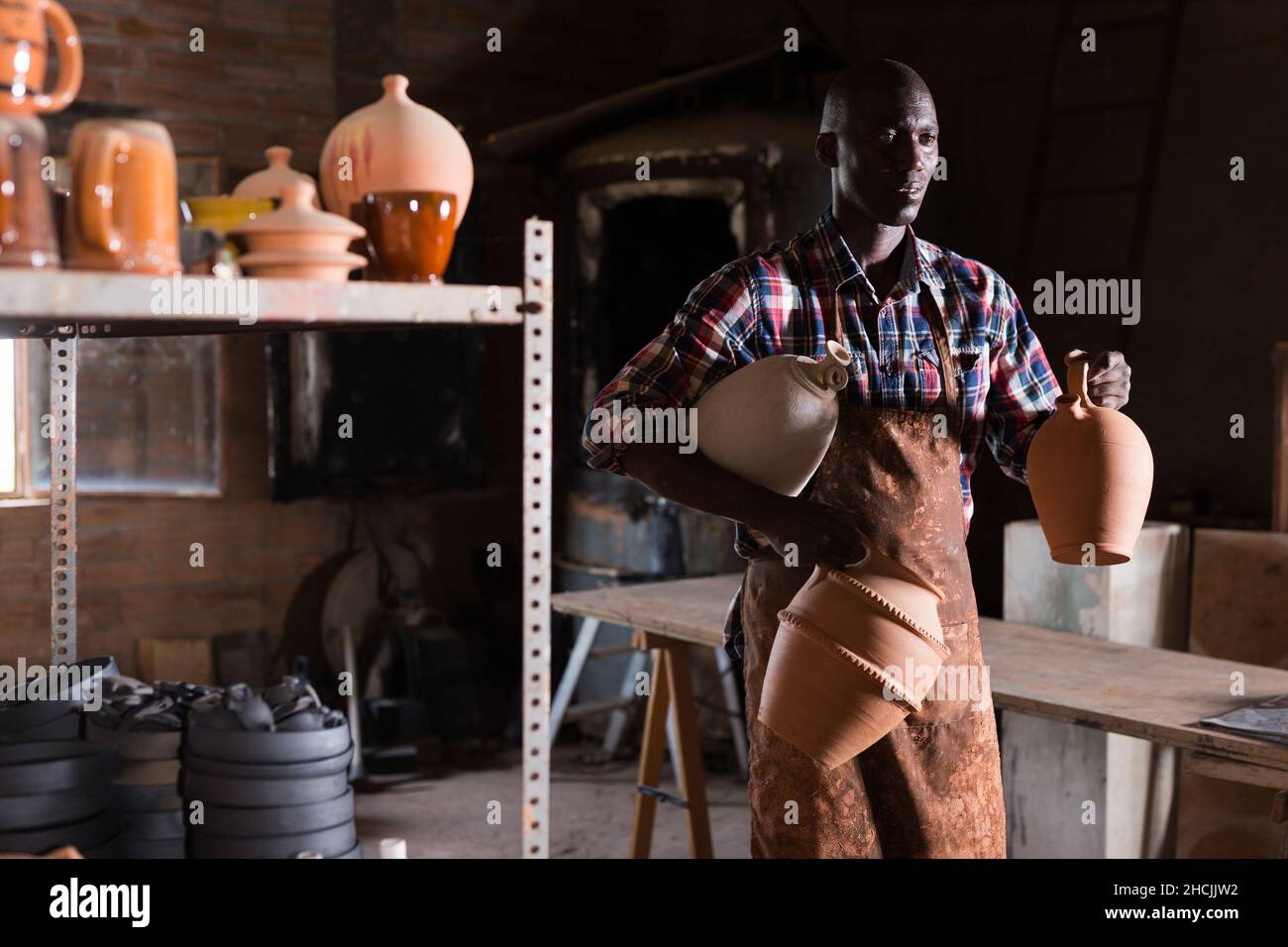 Artigiano che trasporta merci di ceramica Foto Stock