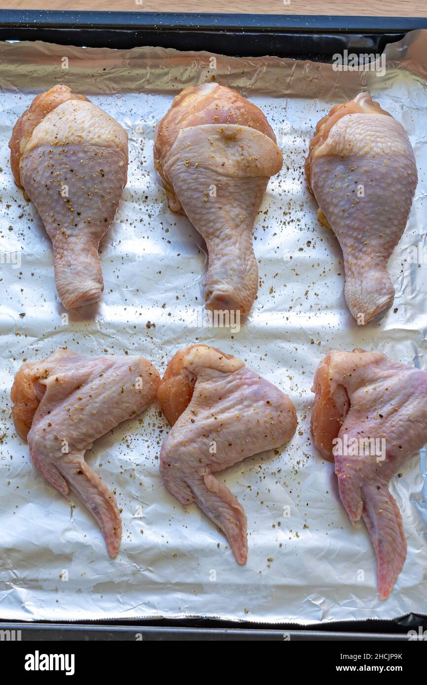 Foto verticale di cosce e ali di pollo crudo Foto Stock