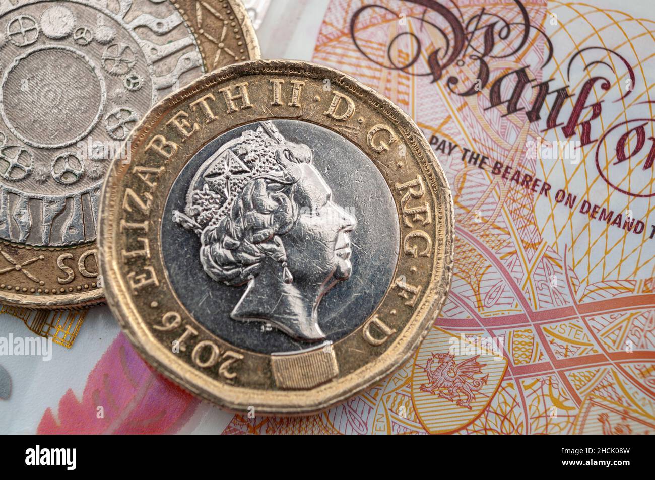 Business e finanza, economia britannica e cambio valuta concetto con macro primo piano su monete da 1 sterlina e due sterline e banconote da 10 GBP Foto Stock