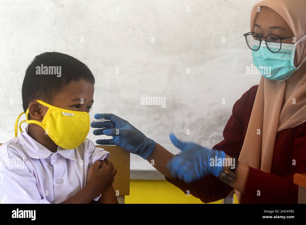 Tangerang, Indonesia. 30th Dic 2021. Un operatore sanitario somministra una dose di vaccino cinese Sinovac COVID-19 a un ragazzo durante la vaccinazione per bambini di età compresa tra i 6 e i 11 anni al villaggio di Cisauk a Tangerang, provincia di Banten, Indonesia, 30 dicembre 2021. Credit: Agung Kuncahya B./Xinhua/Alamy Live News Foto Stock