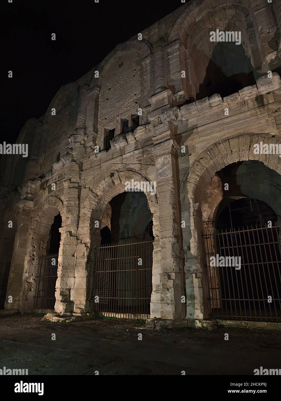 Vista sul maestoso anfiteatro romano, patrimonio dell'umanità dell'UNESCO, nel centro storico di Arles, Provenza, Francia in serata. Foto Stock