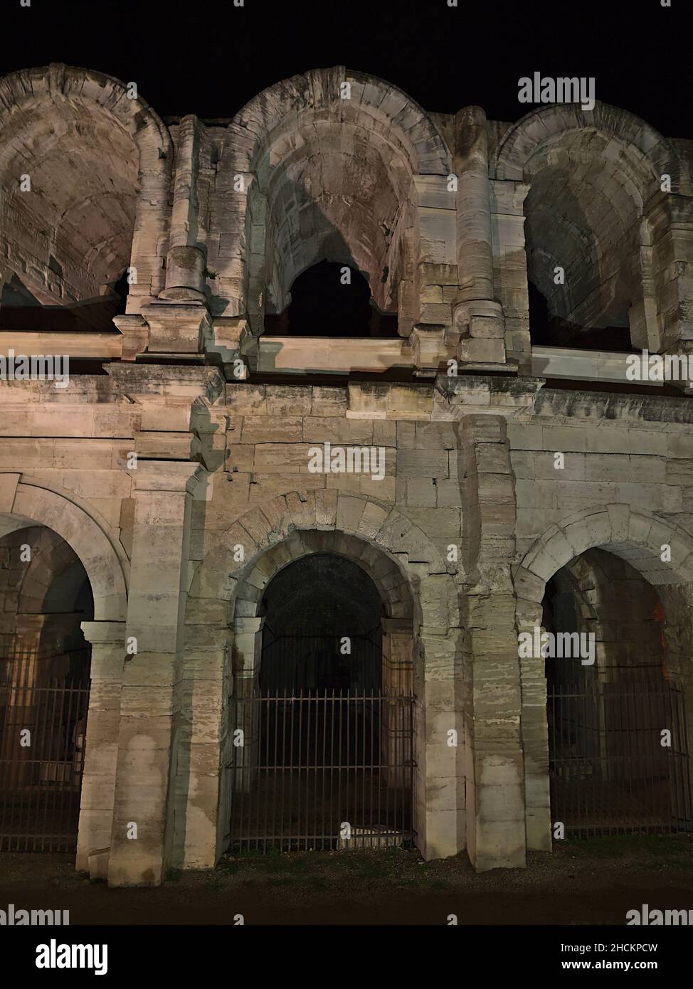 Vista sul famoso anfiteatro romano, patrimonio dell'umanità dell'UNESCO, nel centro storico di Arles, Provenza, Francia di notte. Foto Stock