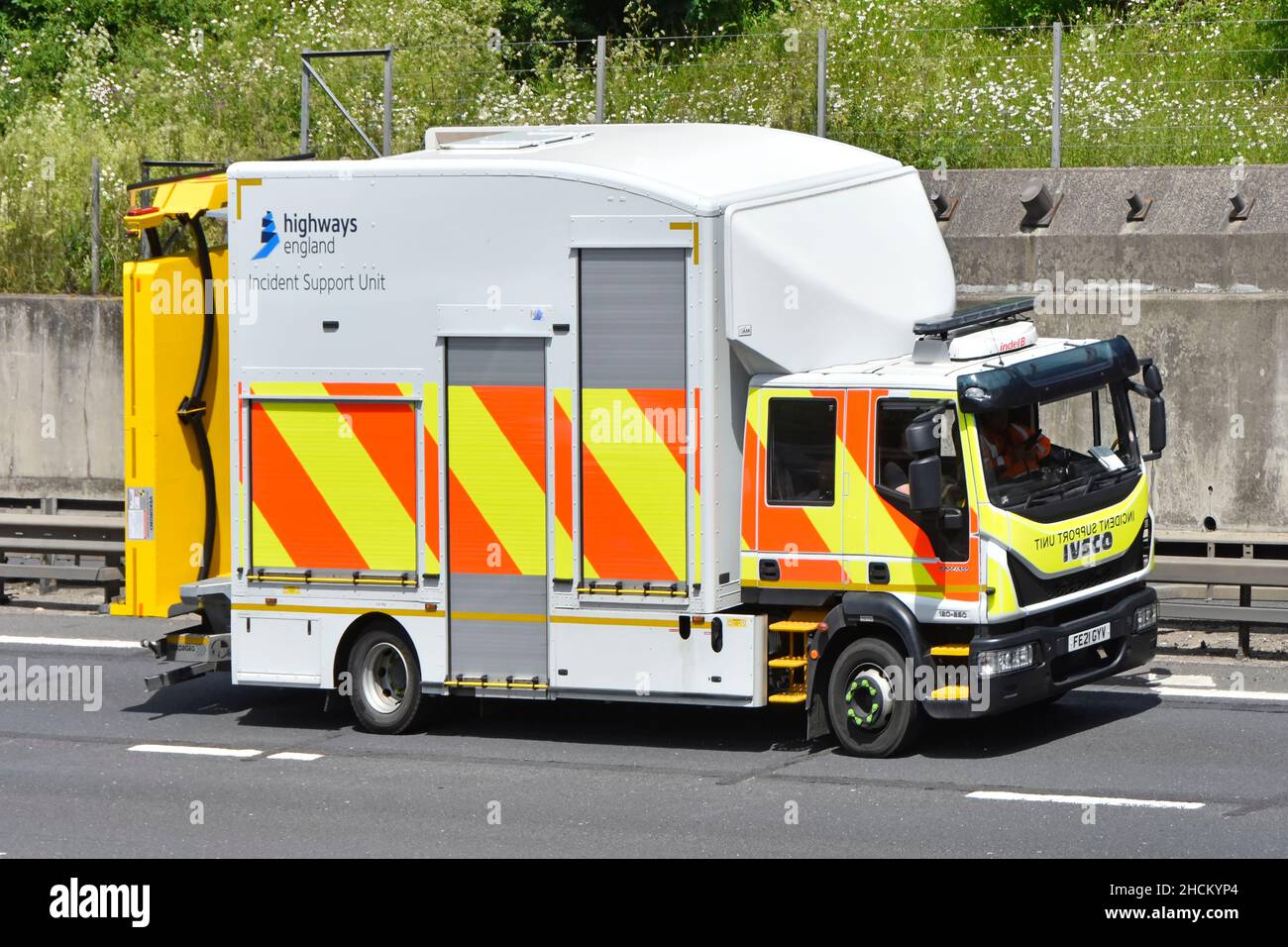 Vista laterale autostrade Inghilterra Iveco supporto incidenti autocarro motrice posteriore rivolto verso il pannello di segnalazione illuminato e strisce riflettenti autostrada UK Foto Stock
