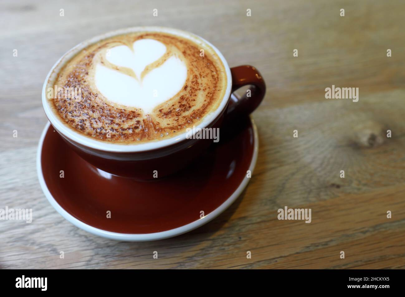Un cappuccino con caffè decorato con arte del design a cuore Foto Stock