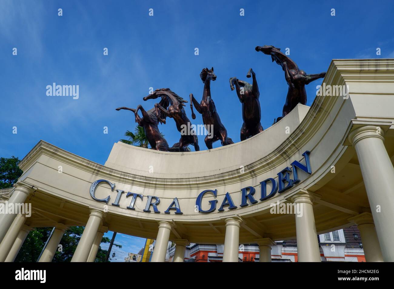 Medan, Indonesia - Novembre 2021 : cinque statue di cavalli di ferro sui pilastri dell'ingresso residenziale con il cielo blu come sfondo Foto Stock