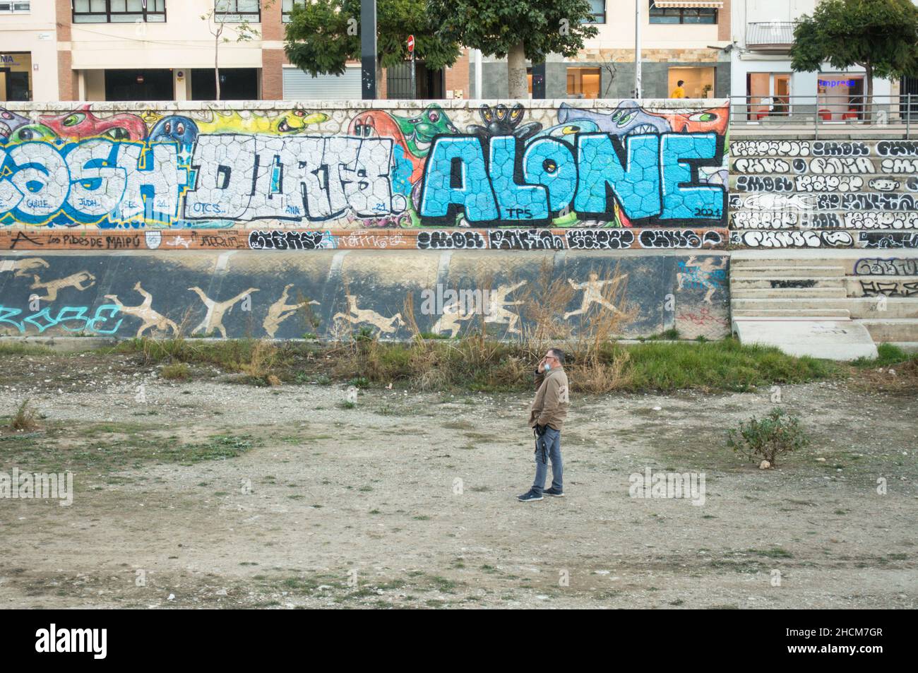 Uomo al telefono in un letto di fiume asciutto, Malaga, Spagna. Foto Stock