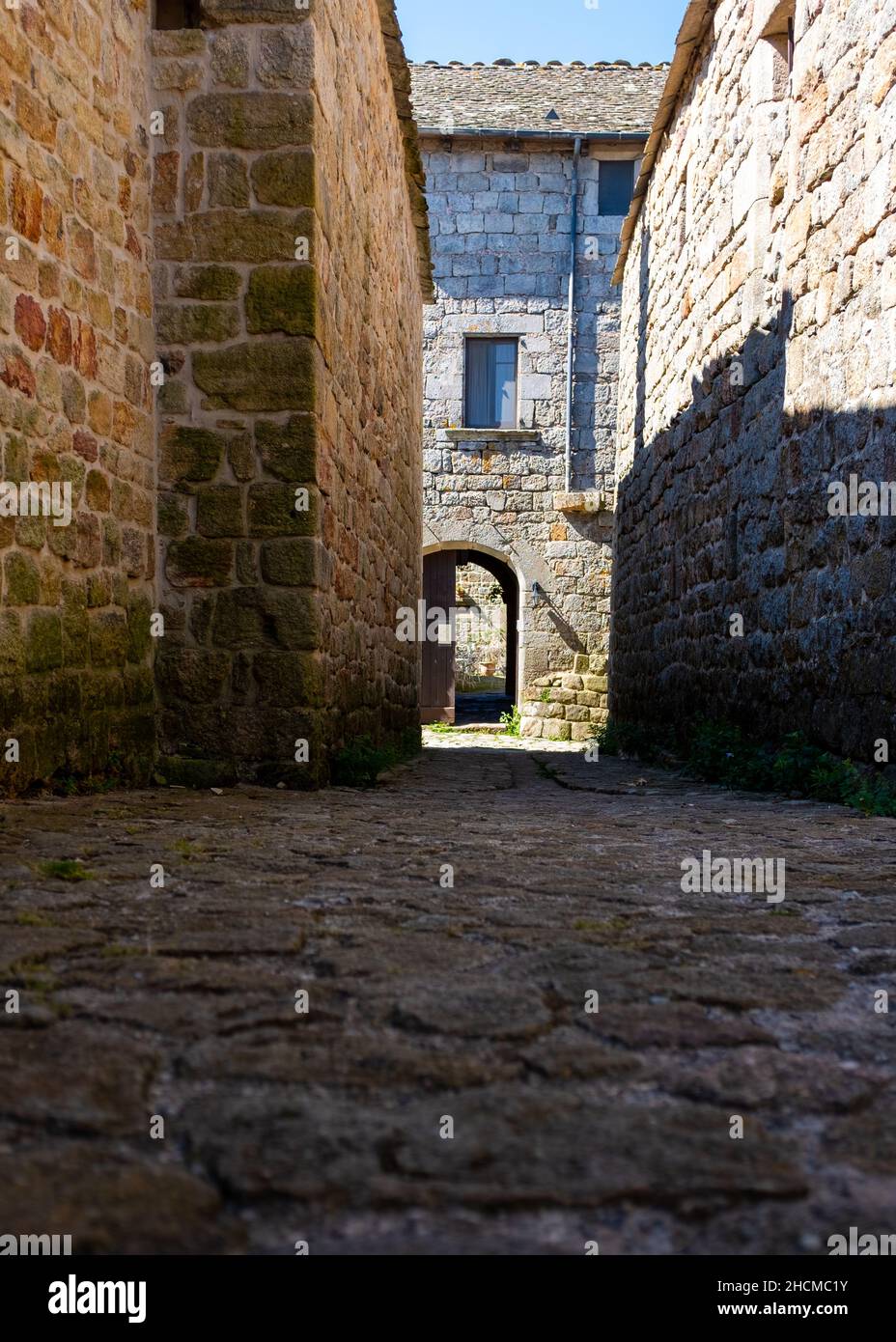 Una strada acciottolata nel villaggio patrimonio di la Garde-Guérin (Francia meridionale), in un pomeriggio estivo soleggiato senza gente Foto Stock