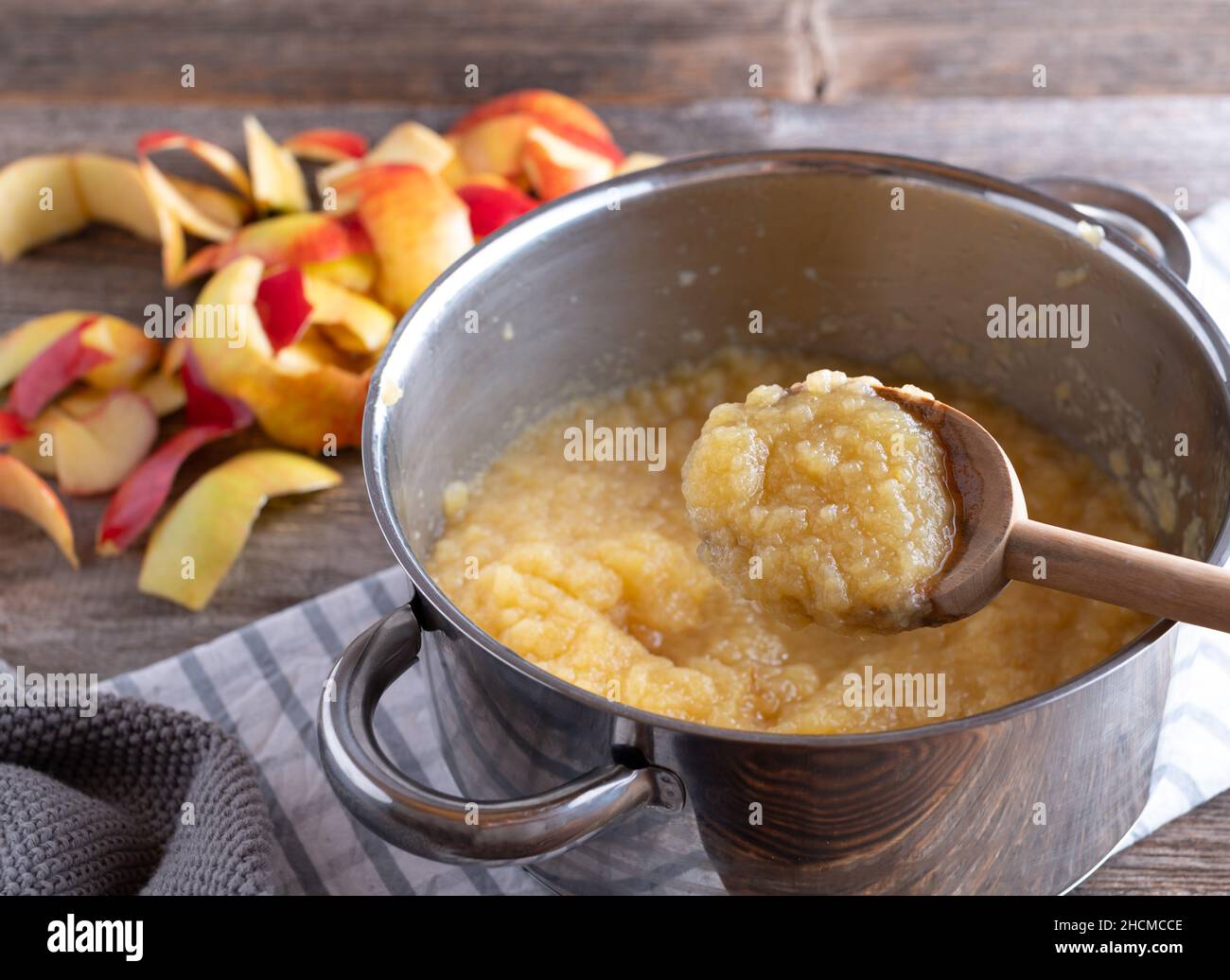 Salsa di mele fatta in casa in una pentola con cucchiaio di legno Foto Stock