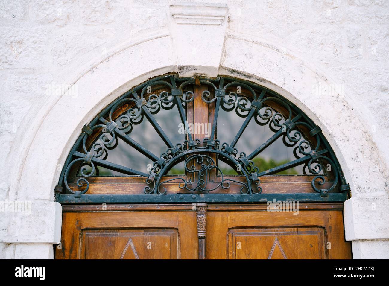 Reticolare in ferro battuto in metallo monogrammed su porta in legno Foto Stock