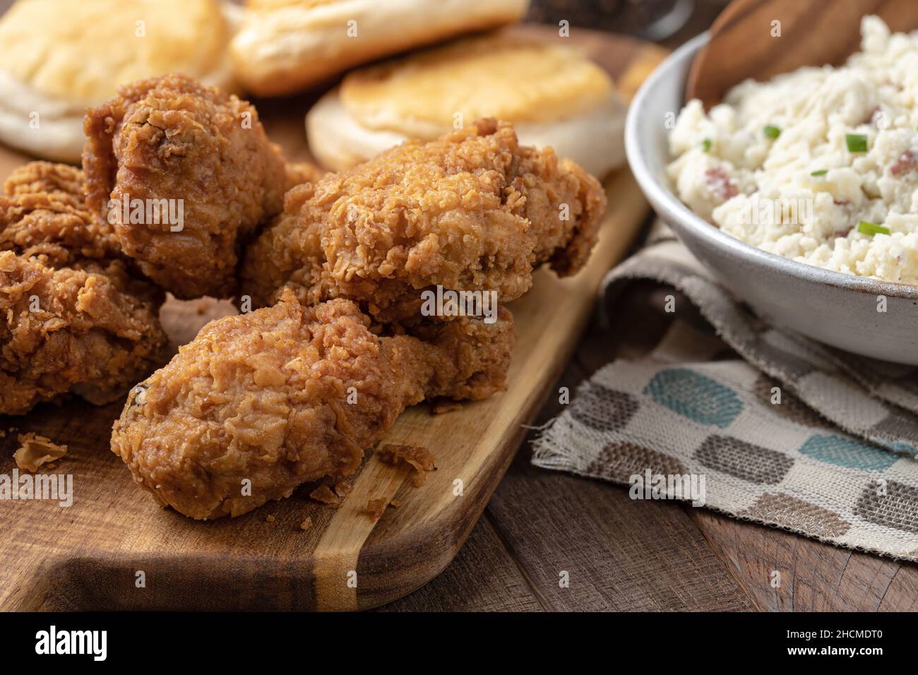 Cena con coscia e coscia di pollo fritto con biscotti e purè di patate su un rustico tavolo in legno Foto Stock