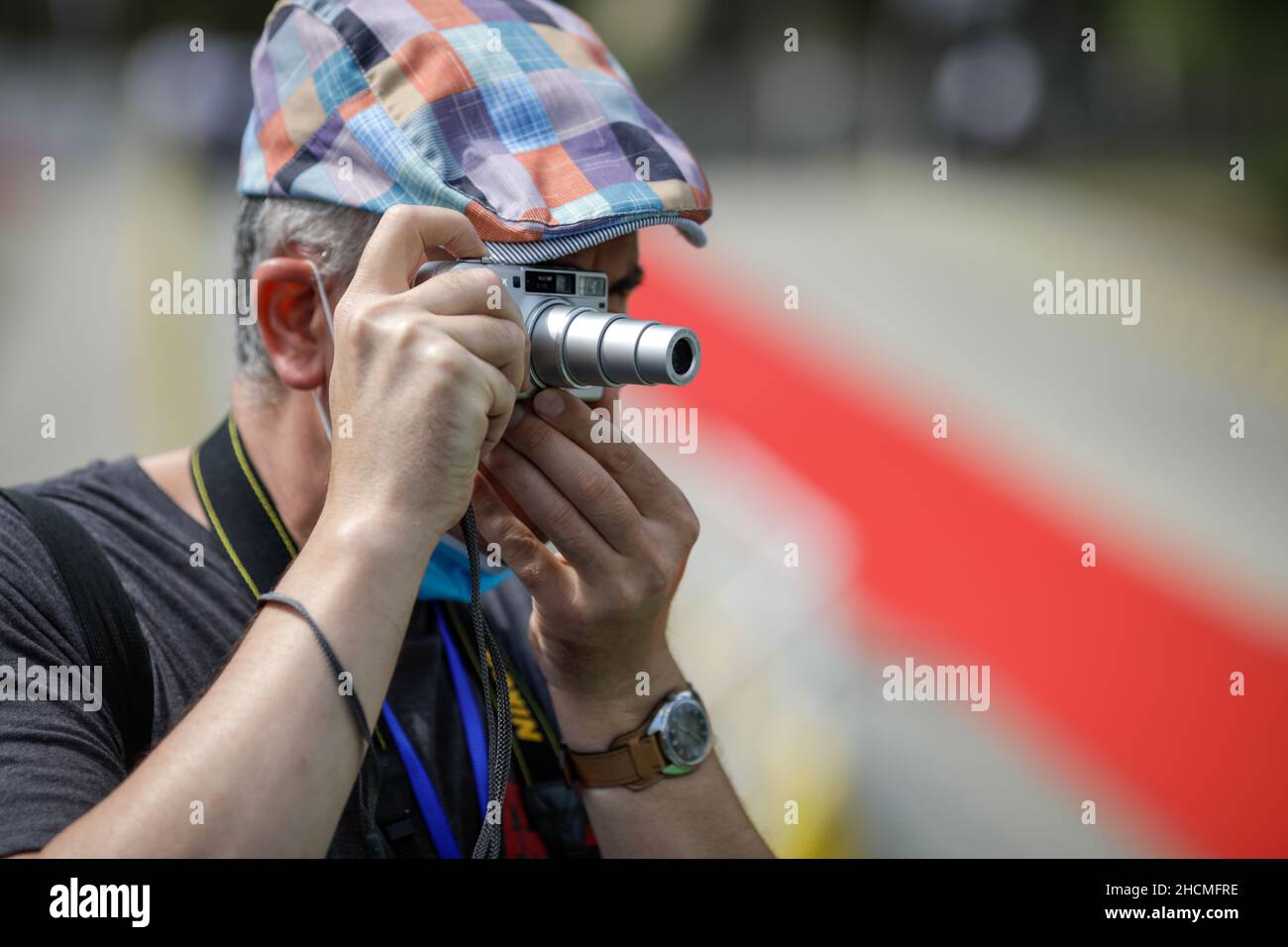 Braila, Romania - 26 agosto 2021:profondità di campo poco profonda (fuoco selettivo) dettagli con un uomo che scatta foto con una piccola fotocamera compatta. Foto Stock