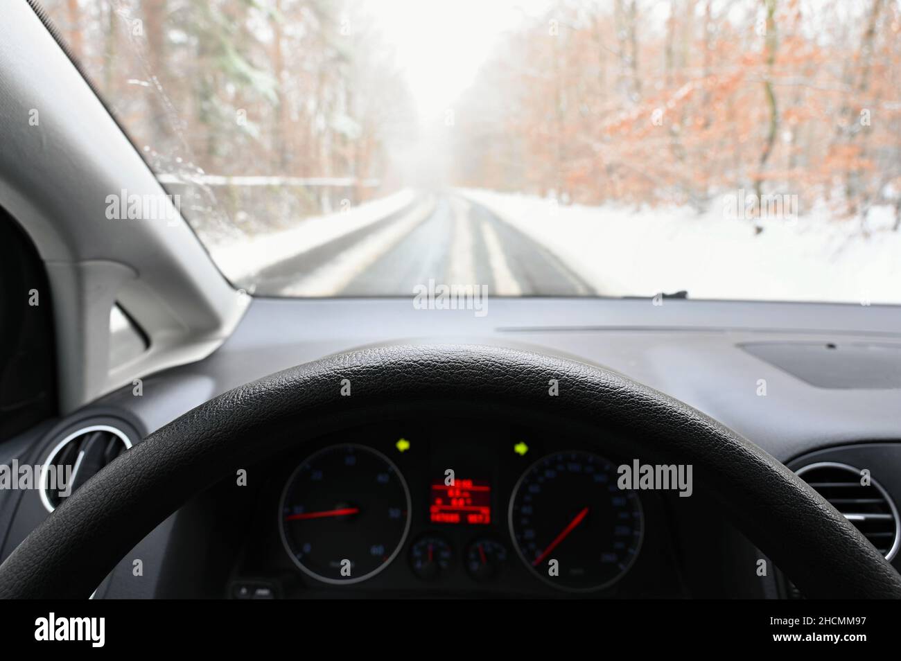 Stagione invernale pericolosa con neve su strada. L'interno della vettura dal punto di vista del conducente - traffico pericoloso in cattive condizioni meteorologiche. Foto Stock