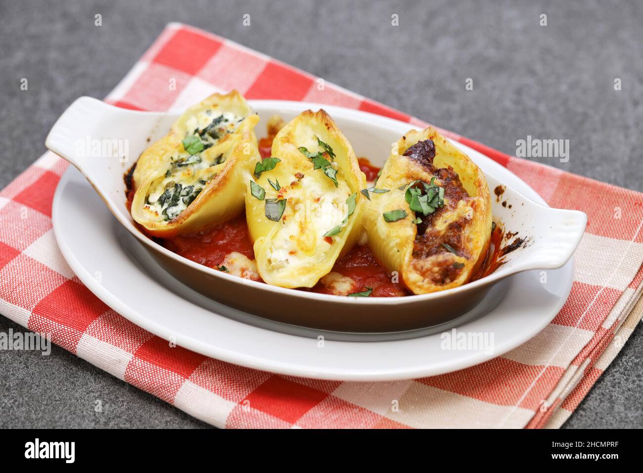 Conchiglioni ripieni di ragu, ricotta e spinaci. Cucina italiana Foto Stock