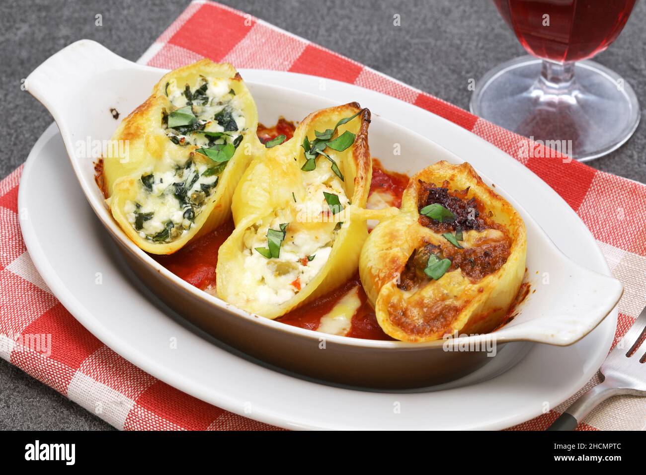 Conchiglioni ripieni di ragu, ricotta e spinaci. Cucina italiana Foto Stock