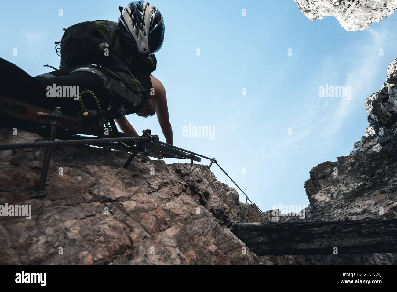 La ragazza sale su una lettera di via ferrata su una montagna massiccia al Toblinger Knoten nelle Dolomiti, Italia Foto Stock