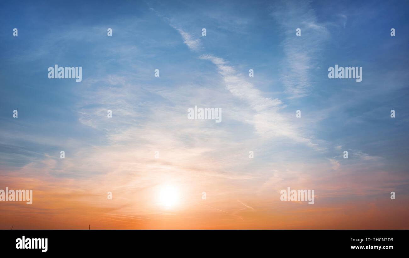 Cielo azzurro e ambra calmo con sole al tramonto. Vista panoramica dai colori luminosi Foto Stock
