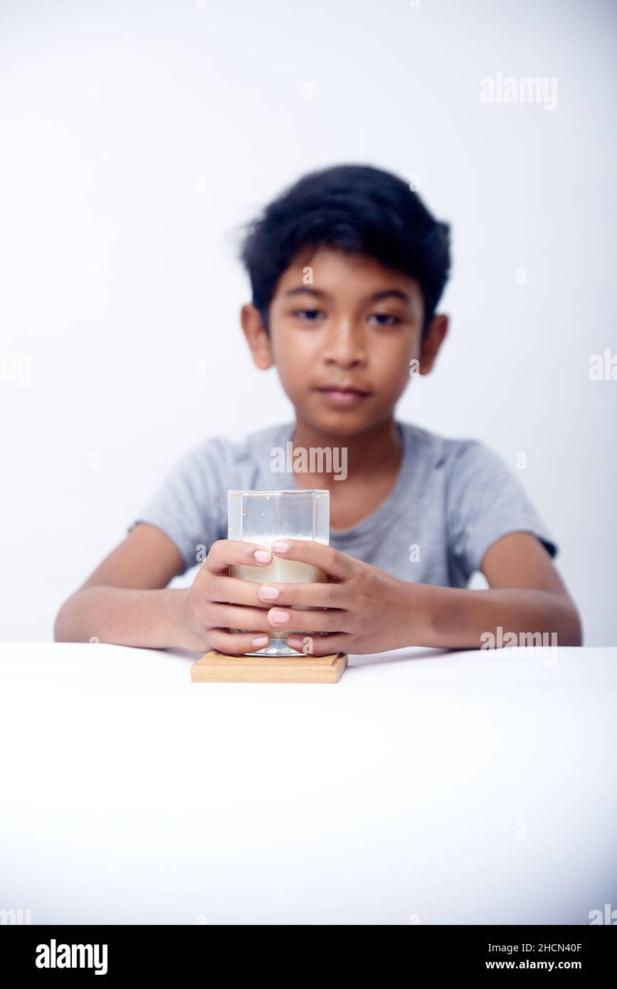 Il ragazzino beve un bicchiere di latte fresco Foto Stock