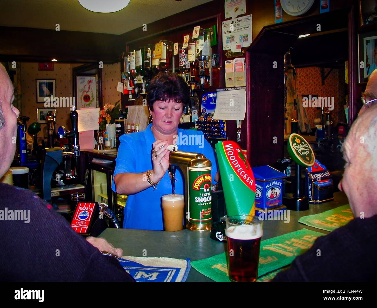 La barmaid tira una pinta di birra in un pub inglese Foto Stock