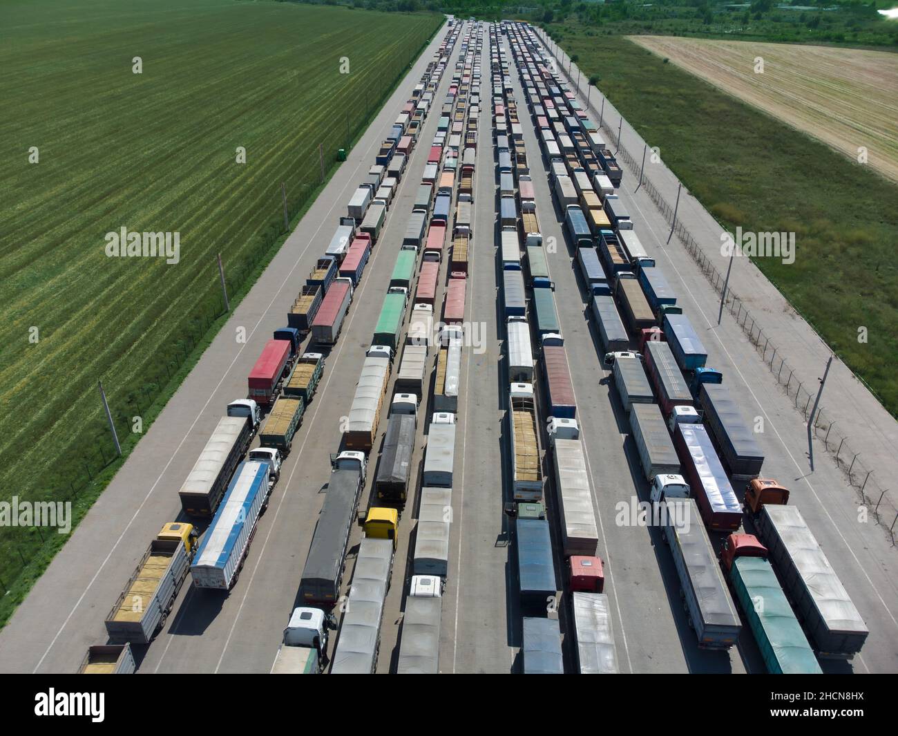 Lunga coda di camion nel porto al terminal. Vista dall'alto del parcheggio in attesa di scarico Foto Stock