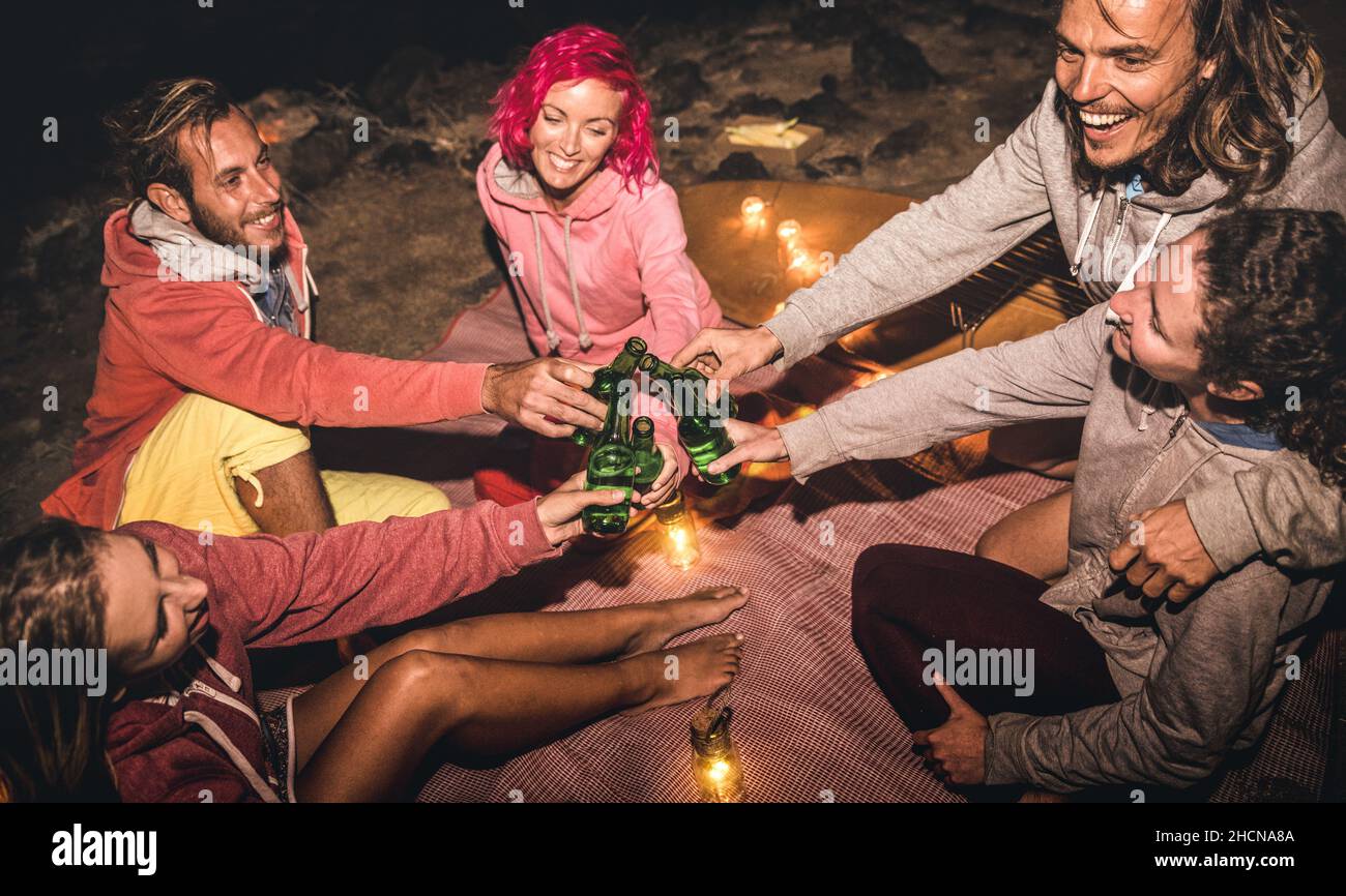 Giovani amici hipster divertirsi insieme al Beach party notturno con luce del fuoco - concetto di viaggio amicizia con i giovani viaggiatori Foto Stock