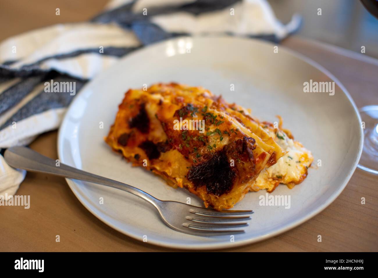 Primo piano di un pezzo di lasagne di formaggio appena sfornate sul piatto Foto Stock