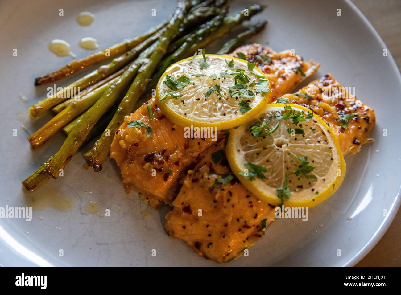 Un primo piano del salmone appena arrostito con asparagi sul piatto Foto Stock