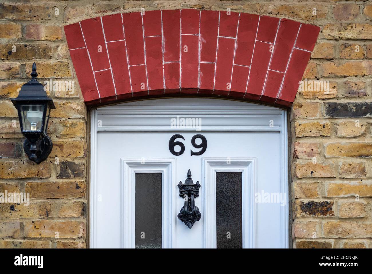 Casa numero 69 sotto un arco di mattoni Foto Stock