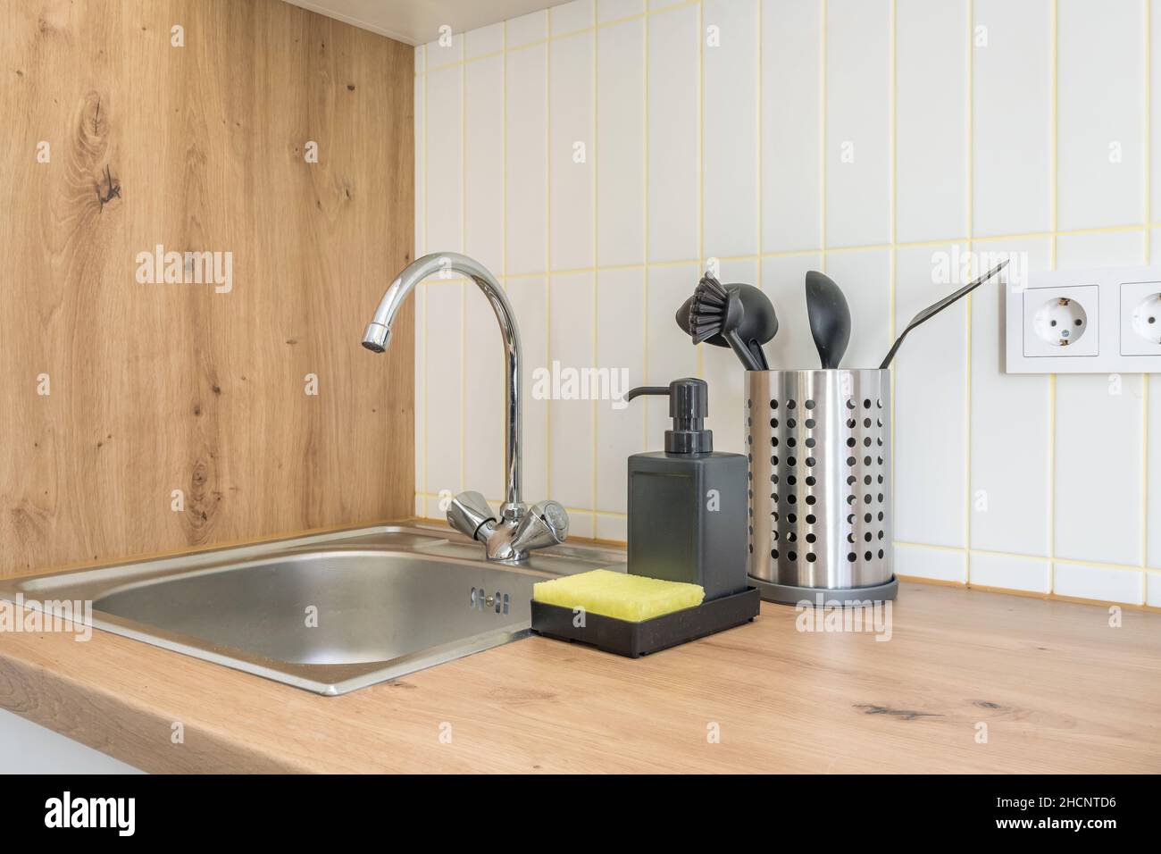 Distributori di sapone e shampoo vicino al lavello del rubinetto dell'acqua in ceramica con rubinetto in cucina costosa Foto Stock