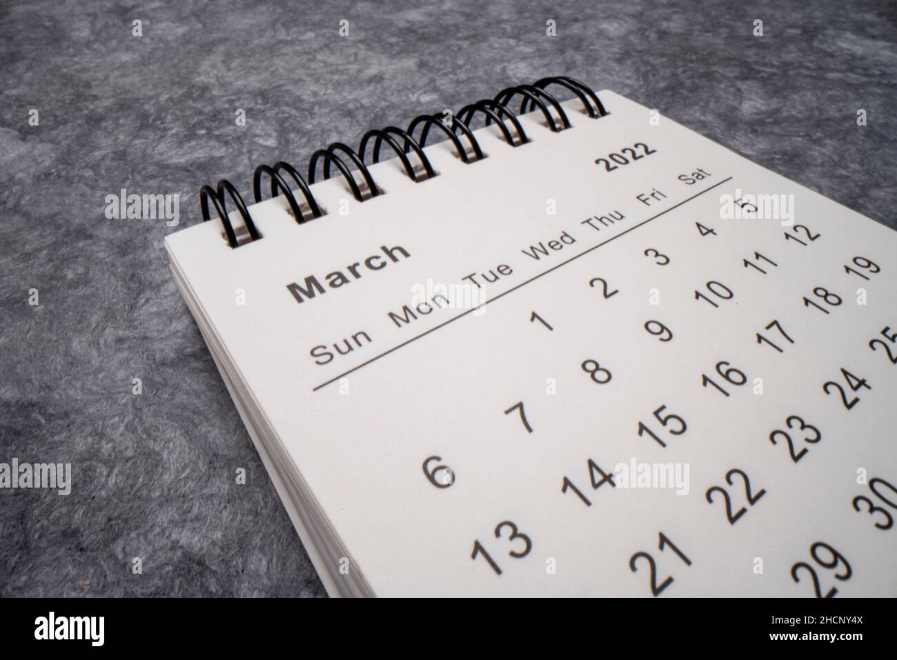 Marzo 2022 - calendario desktop a spirale contro carta grigia testurizzata, concetto di tempo e business, macro shot dal punto di vista dell'obiettivo della sonda Foto Stock