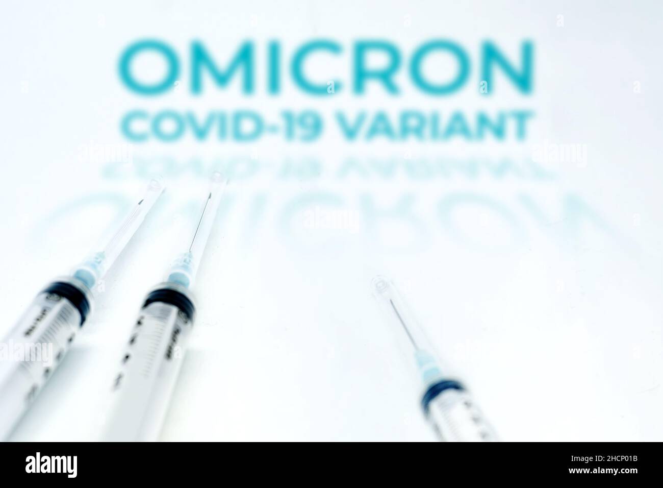 La variante Omicron Covid-19 offuscava il testo su due siringhe isolate su sfondo bianco. Mutazione del coronavirus Covid-19. Prevenzione e vaccino Foto Stock
