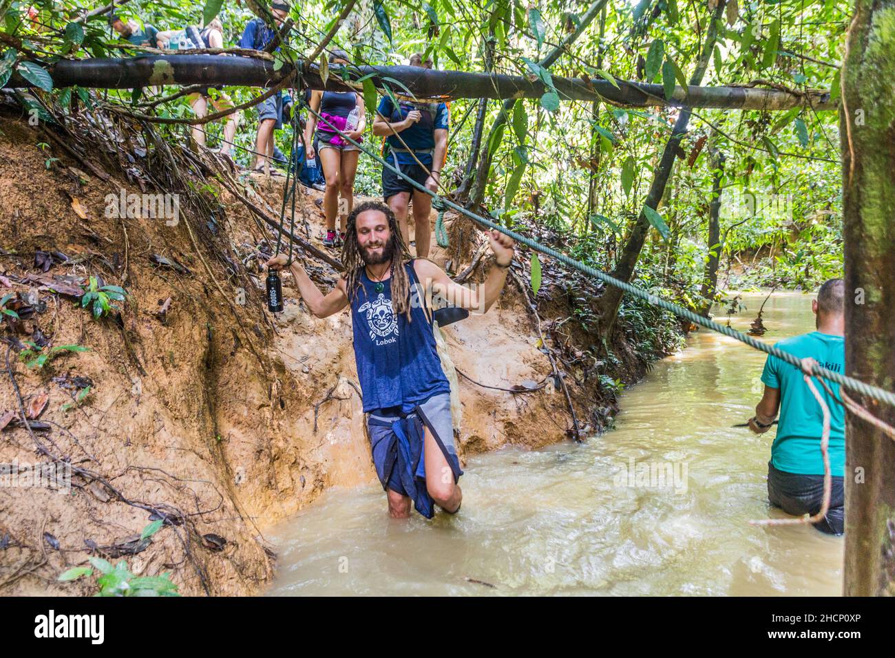 TAMAN NEGARA, MALESIA - 16 MARZO 2018: I turisti attraversano un torrente nella giungla del parco nazionale Taman Negara. Foto Stock