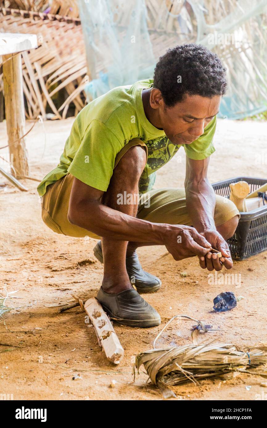 TAMAN NEGARA, MALESIA - 17 MARZO 2018: L'uomo indigeno che fa freccette per un blowpipe nel suo villaggio nel parco nazionale di Taman Negara, Malesia Foto Stock