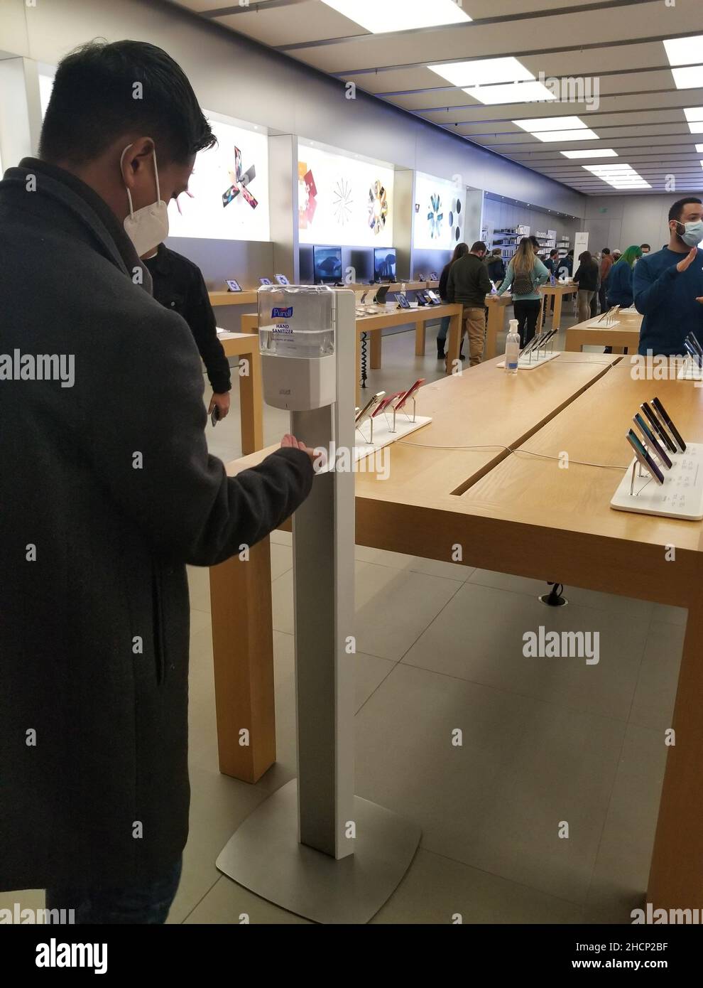 Delaware, U.S.A - 17 dicembre 2021 - un cliente che utilizza l'igienizzatore pubblico a mano all'interno dell'Apple Store all'interno del Christiana Mall Foto Stock