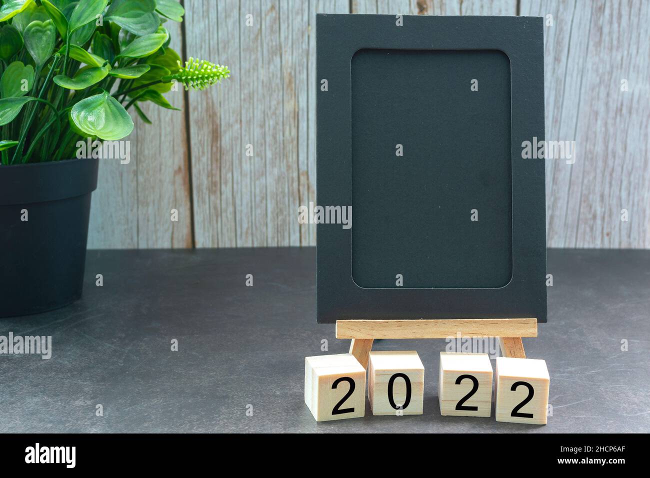 Blocco di legno di 2022 con blocco note nero su una scrivania. 2022 concetto di Capodanno Foto Stock