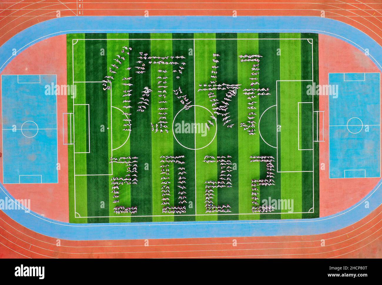 HANDAN, CINA - 31 DICEMBRE 2021 - una foto aerea scattata il 31 dicembre 2021 mostra agli studenti della scuola media celebrare il nuovo anno formando 'HELLO 202 Foto Stock