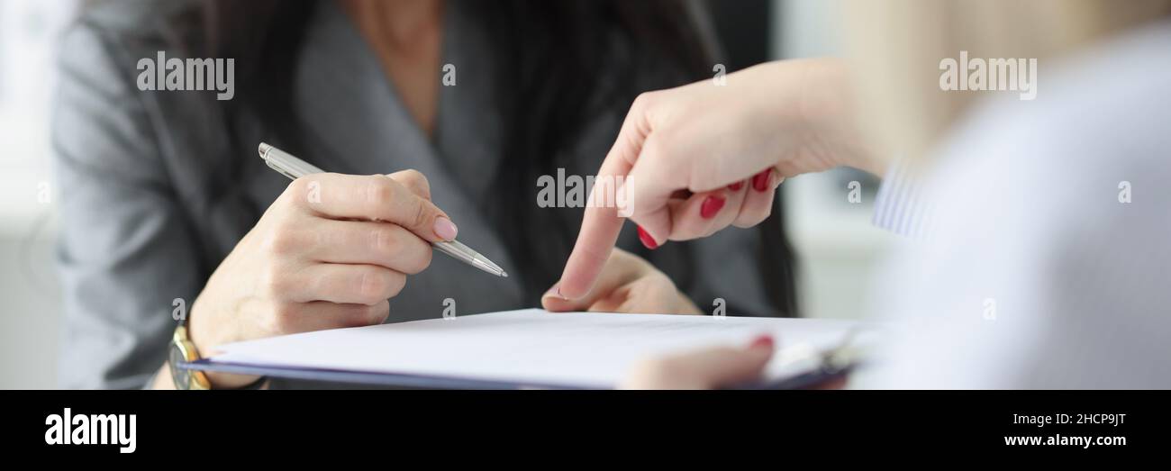 Avvocato che punta al contratto di assicurazione che mostra cliente a donna dove firmare Foto Stock