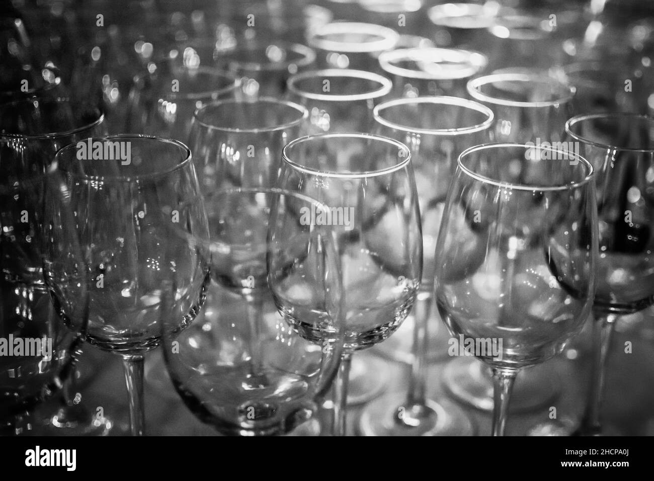 una collezione di bicchieri da vino su un bancone da bar pronti per l'uso di immagini astratte in bianco e nero Foto Stock