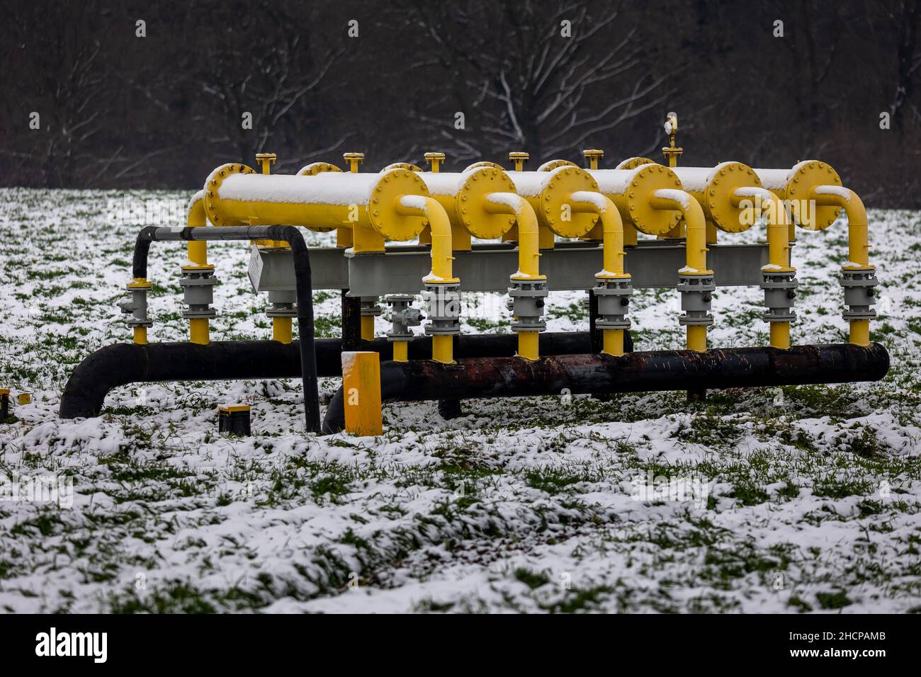 Elementi dell'infrastruttura del gas giallo che sporgono dal suolo. Foto invernale di un gasdotto coperto di neve. Prezzi elevati del gas naturale. La foto era tak Foto Stock