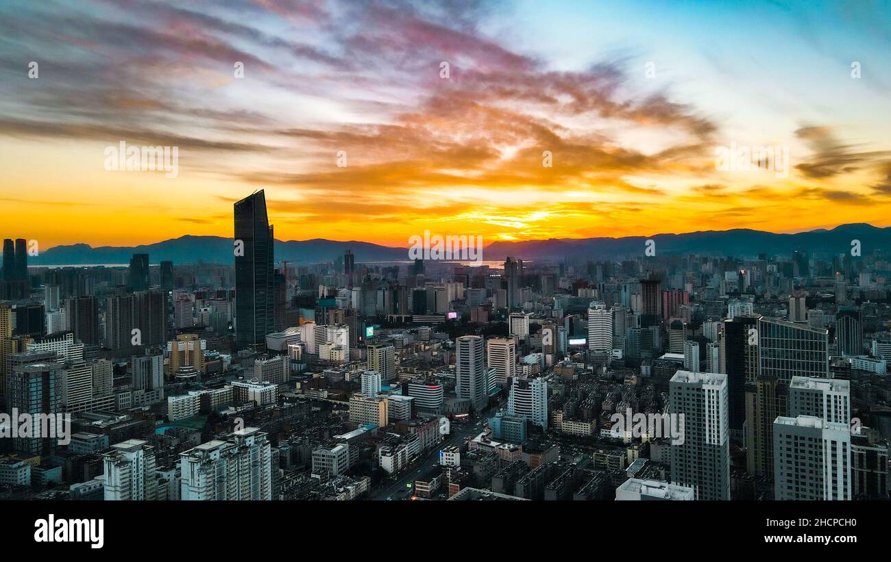 KUNMING, CINA - 30 DICEMBRE 2021 - Foto aerea scattata il 30 dicembre 2021 mostra uno spettacolare paesaggio urbano al tramonto a Kunming, provincia di Yunnan, Cina. Foto Stock