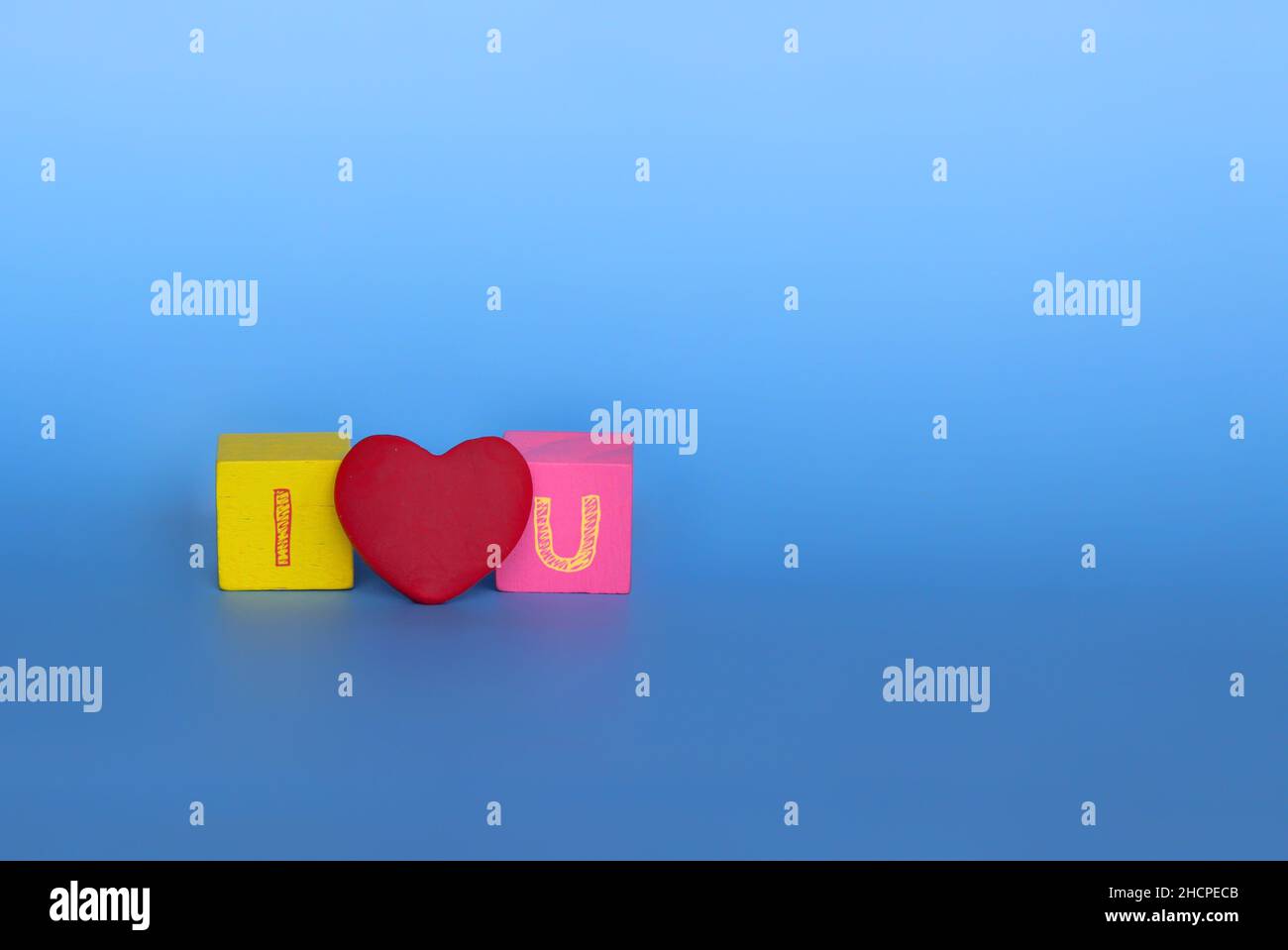 Amore e concetto romantico. AMO il testo U fatto da cubi di legno e cuore rosso. Foto Stock
