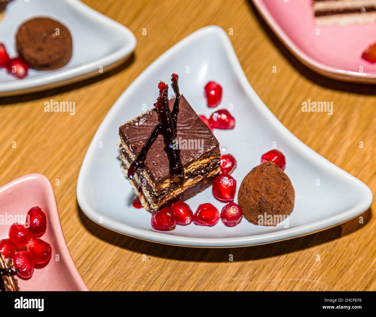 Diversi piatti di dessert a strati delle Onde del Danubio con semi di melograno sono disposti vicini su un tavolo di legno, fotografati durante un evento culinario a Grevenbroich, Germania. Foto Stock