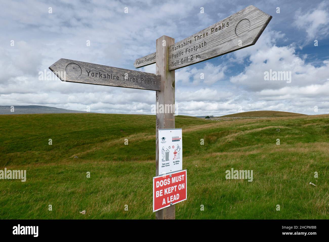 Cartello con indicazione di sentiero pubblico in legno tra Horton a Ribblesdale e Ribblehead che fornisce indicazioni per Yorkshire Three Peaks Walk Foto Stock