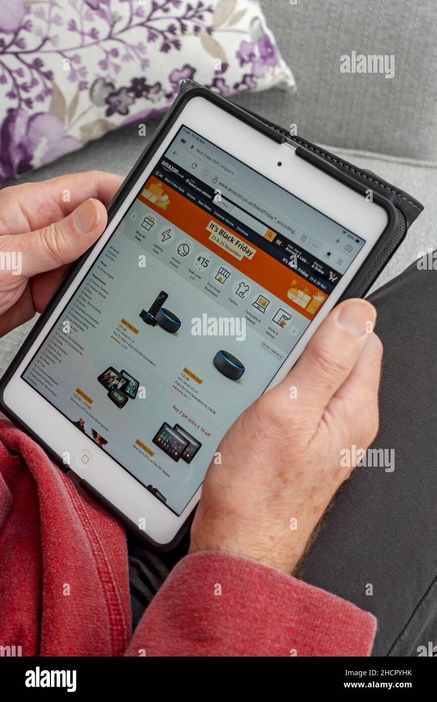 Primo piano di un uomo che guarda il sito Web di shopping Amazon Black Friday su uno schermo tablet ipad Inghilterra Regno Unito Regno Unito Gran Bretagna Foto Stock